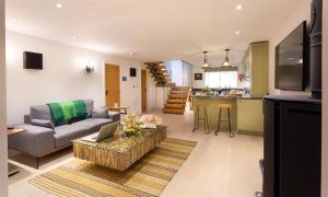 a living room with a couch and a table and a kitchen at Shepherd's View in Kendal
