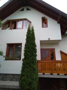 a white house with a tree in front of it at Casa Lacul Mierlei in Sovata