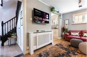 a living room with a red couch and a flat screen tv at Perfect For Professionals & Families - Allocated Parking - WIFI in Canterbury