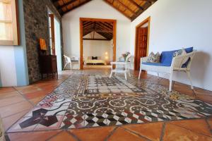 Casa Rural Vista del Mar في إرميغوا: غرفة معيشة مع أريكة زرقاء وأرضية من البلاط