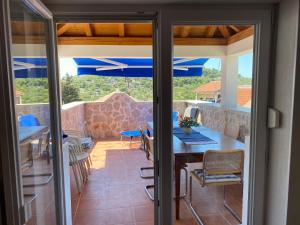 a patio with a table and chairs and blue umbrellas at Villa Mediterranea in Murter