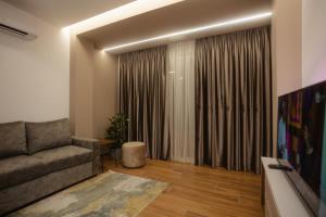 a living room with a couch and a large window at KOMPLEKSI ROYAL in Velipojë