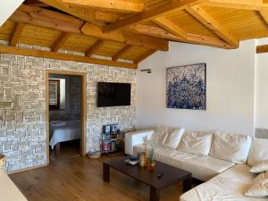 a living room with a white couch and a stone wall at Villa Mediterranea in Murter
