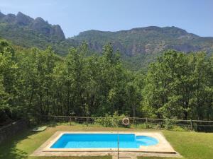 una piscina con montañas en el fondo en Hotel Rural El Mirador de los Pirineos, en Santa Cruz de la Serós
