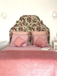 een bed met een roze sprei en 2 roze kussens bij LE VIEUX MOULIN in Bouhet