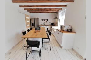 une cuisine avec une table en bois et des chaises noires dans l'établissement La Cabanna maison Pléneuf-Val-André à 600m de la mer, à Pléneuf-Val-André