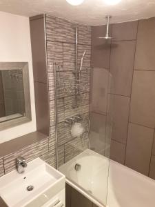 a bathroom with a shower and a sink and a sink at Papworth apartment in Papworth Everard