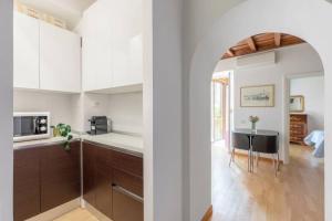 kuchnia z białymi szafkami i stołem w pokoju w obiekcie iFlat Via del Corso Elegant Apartment w Rzymie
