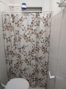 a bathroom with a shower curtain with a toilet at Hotel 678 in Boa Vista