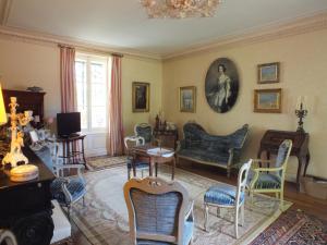 a living room with chairs and a table and a couch at Château de Nazé in Vivy