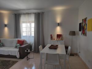 a living room with a white table and a couch at Dunas Mar in Alvor