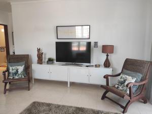 a living room with two chairs and a flat screen tv at Dunas Mar in Alvor