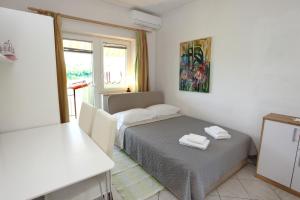 ein kleines Zimmer mit einem Bett und einem Fenster in der Unterkunft Bozena Studio KNEB in Portorož