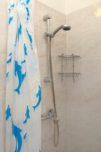 eine Dusche mit einem blauen Delfinduschvorhang im Bad in der Unterkunft Bozena Studio KNEB in Portorož + 23 Fotos