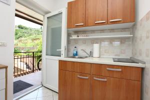 eine Küche mit einem Waschbecken und eine Tür zu einem Balkon in der Unterkunft Bozena Studio KNEB in Portorož