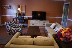 sala de estar con sofá y TV en Red Carpet Inn & Suites Culpeper, en Culpeper