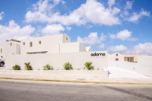 a white building with a sign on it at Adorno Oia in Oia