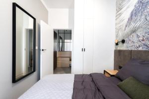 - une chambre avec un lit et un miroir dans l'établissement Apartament Voila, à Varsovie