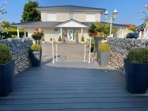 a walkway leading to a house with flower pots at Pension Cao Lai in Varel