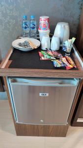 a table with a plate and drinks on top of it at Papilukas Room Grand Kamala Lagoon - Studio East in Bekasi