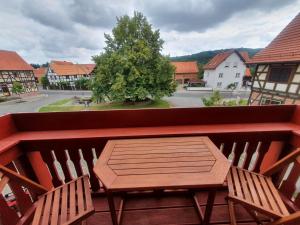 einen Holztisch und zwei Stühle auf dem Balkon in der Unterkunft Altes Pfarrhaus Neustädt in Neustädt