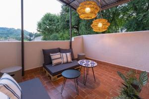 un patio con divano, tavolo e sedie. di FLOR DE LIS a Sant Hilari Sacalm