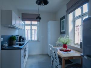 a kitchen with a wooden table and a kitchen with blue walls at ferienwohnungen1886 in Borsdorf