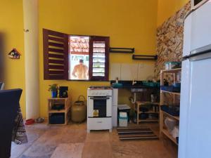 a kitchen with a stove and a window in it at Casinha na Praia do Guajiru in Guajiru