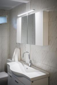 Un baño blanco con lavabo y espejo. en Natalia's Stay, en Thermisía 16 fotos más