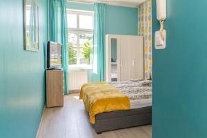 1 dormitorio con cama y pared azul en Pokoje Śródmieście, en Bydgoszcz