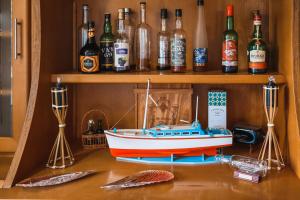 a toy boat sitting on a table with bottles of alcohol at Hotel Comodoro in Corvo