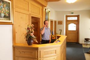 a man talking on his cell phone in front of a mirror at Gasthof Prinzregent Superior in Marquartstein