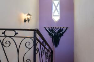 a purple wall with a window and a staircase at Natural Mystic Hostel in Costa da Caparica
