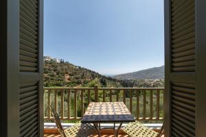 una mesa y sillas en un balcón con vistas en Nysa Residence en Ándros