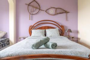 a bedroom with a large bed with purple walls at Natural Mystic Hostel in Costa da Caparica