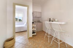 una cocina con 2 sillas y una mesa en una habitación en Nysa Residence en Andros