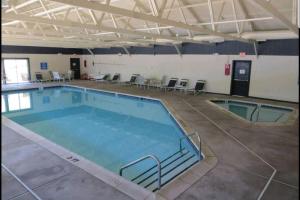 a large swimming pool in a building with tables and chairs at *Amenity-Filled Waterfront Oasis @Saw Creek Estates Near WaterFalls and Hiking* in East Stroudsburg