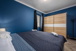 1 dormitorio azul con 1 cama grande y paredes azules en Premium Apartment Daka, en Poreč