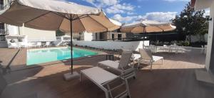 uma piscina com cadeiras e guarda-sis numa varanda em Hotel Pantanha Nature & Fitness nas Caldas da Felgueira