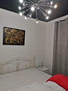a bedroom with a white bed with a ceiling fan at Apartament Francuski in Krosno