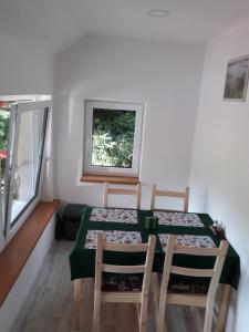 a dining room with a table and chairs and a window at Penzion Pohoda in Jetřichovice