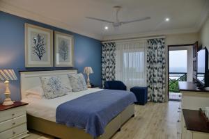 Schlafzimmer mit einem Bett mit blauer Wand in der Unterkunft Pumula Beach Hotel in Umzumbe