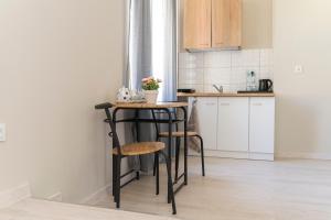 a kitchen with a small table and two stools at Pokoje Śródmieście in Bydgoszcz