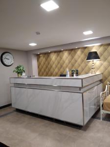 a lobby with a reception desk with a clock at Elaėa Boutique Apartments in Piraeus