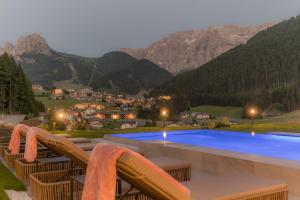 a swimming pool with a view of a mountain at Hotel Rodella in Selva di Val Gardena