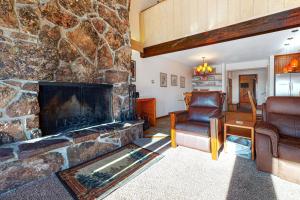 a living room with a stone wall with a fireplace at Timber Ridge 4 in Teton Village