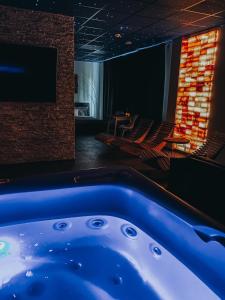 a hot tub in a room with a tv and chairs at Wellness Baška in Baška