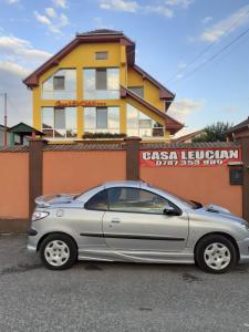 ein silbernes Auto, das vor einem Gebäude parkt in der Unterkunft Casa Leucian in Deva