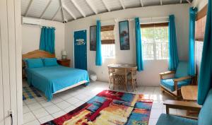 a bedroom with a blue bed and a chair at The Lodge - Antigua in English Harbour Town