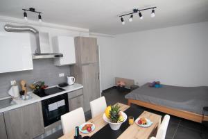 Valkane beach studio apartment في بولا: مطبخ وغرفة معيشة مع طاولة وكراسي